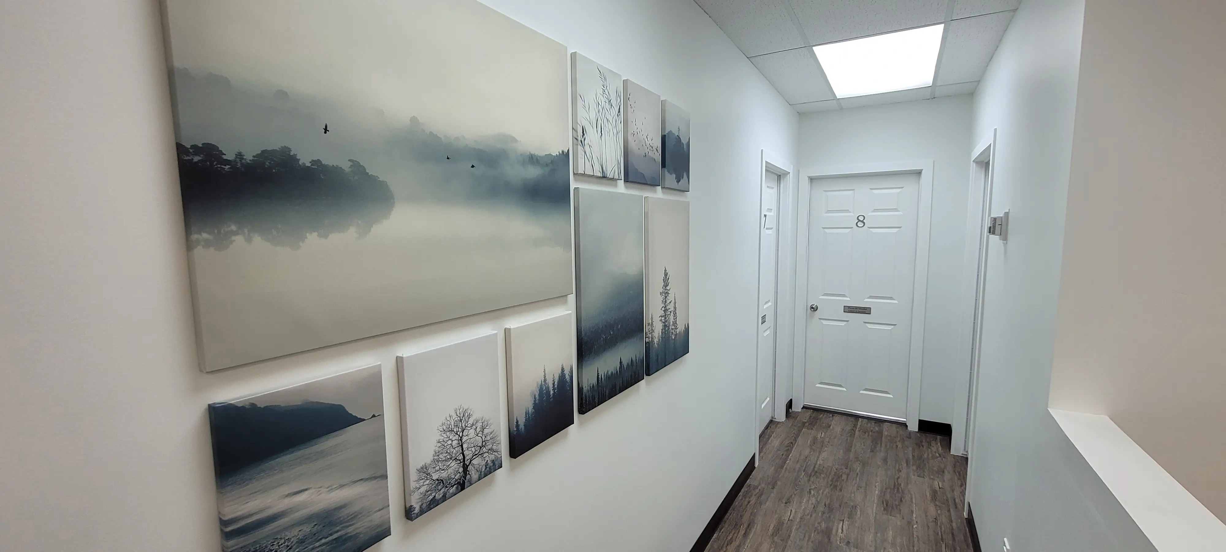 Bright waiting room and hallway in our modern office space in NW Calgary, featuring comfortable seating and artwork.